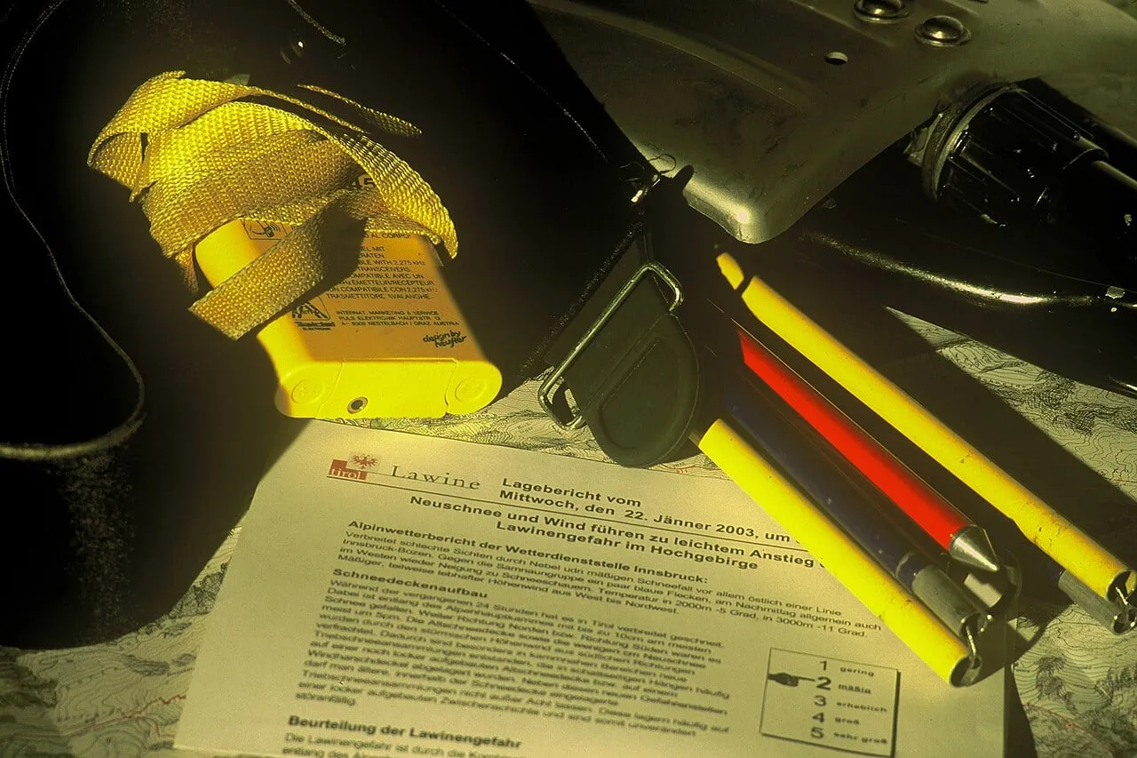 Detektor, łopata i sonda lawinowa na komunikacie lawinowym z pięciostopniową skalą